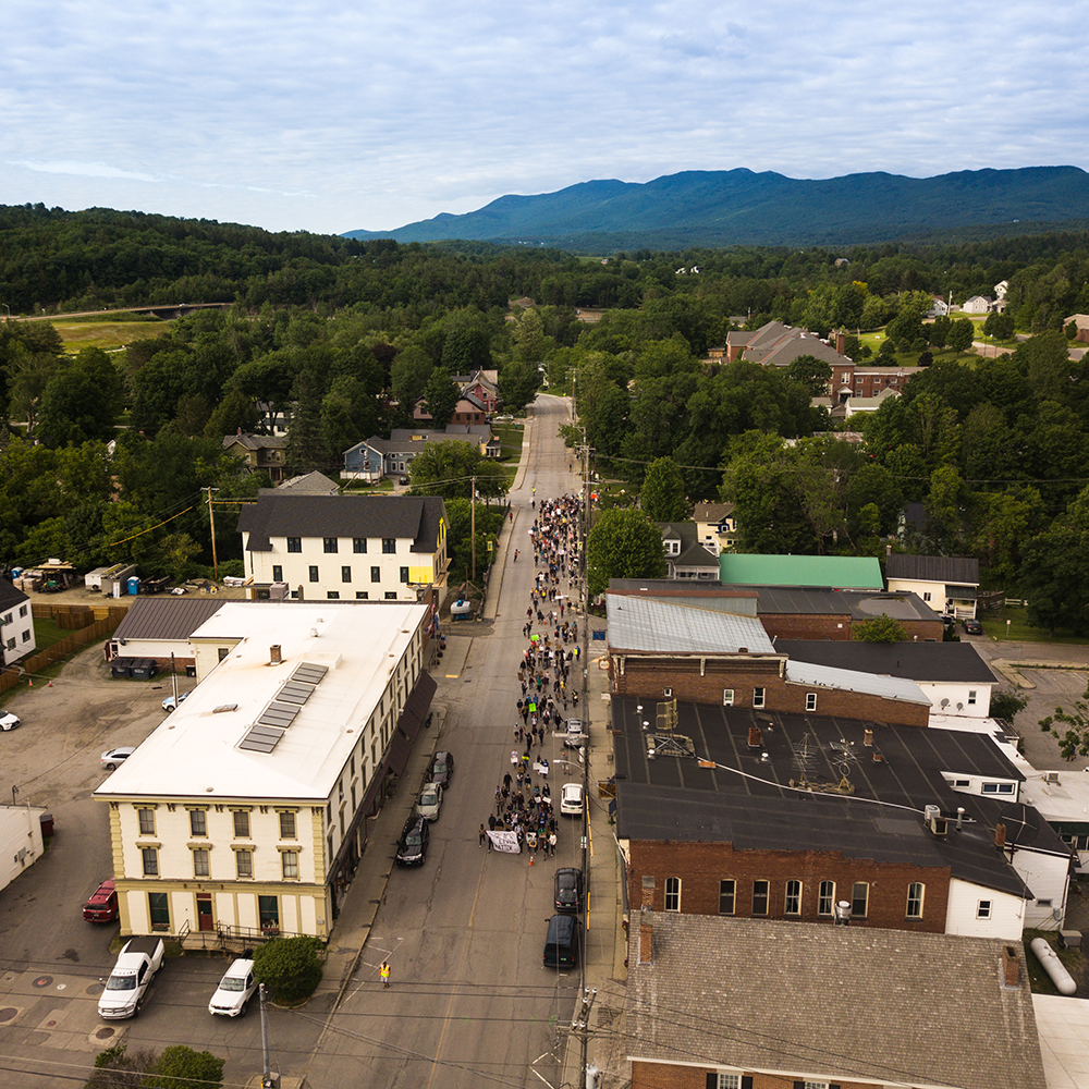 Aerial view of people marching down Stowe Street in Waterbury